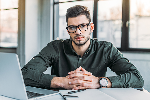 Homem em um escritório trabalhando em uma empresa de tradução em seu notebook