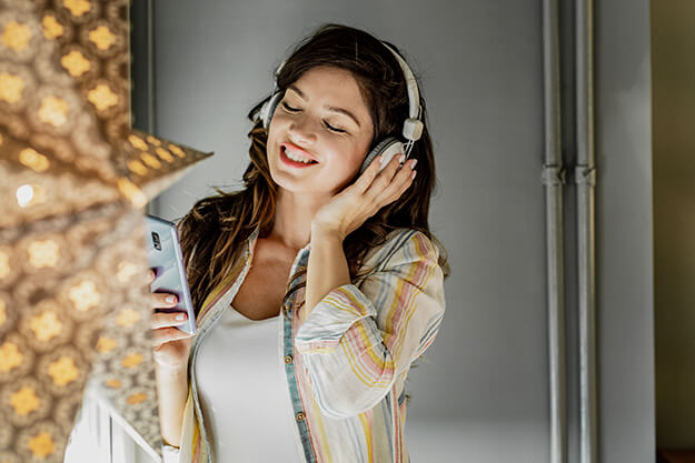 mulher feliz ouvindo podcasts em inglês