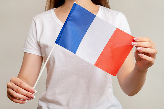 mulher segurando bandeira da França após conseguir cidadania francesa