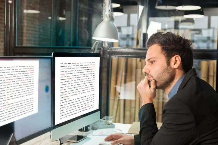 Homem profissional de tradução em frente ao computador realizando seu serviço.