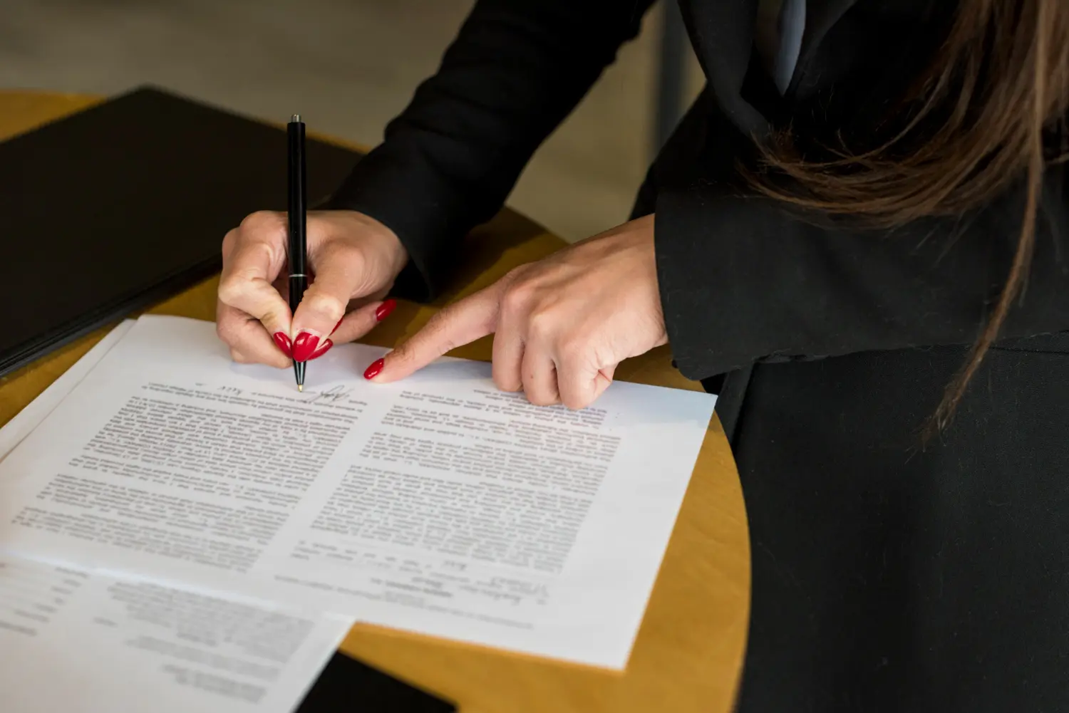 Imagem da mão de uma mulher assinando a tradução juramentada de contrato